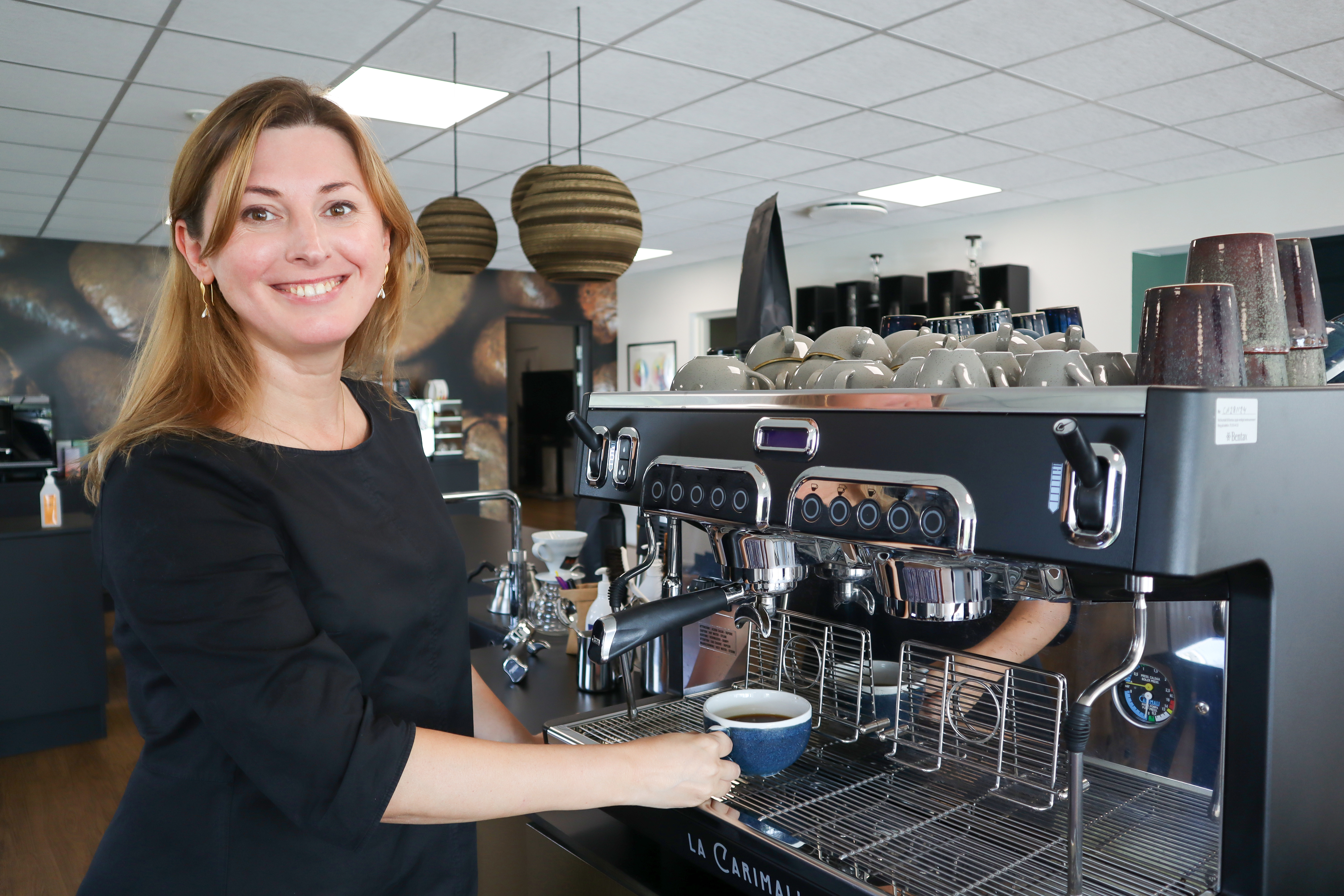 Irina henter en kop kaffe fra en kaffemaskine