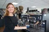Irina henter en kop kaffe fra en kaffemaskine