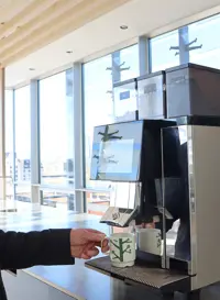 en mand laver en kop kaffe fra en af Bentax kaffemaskiner