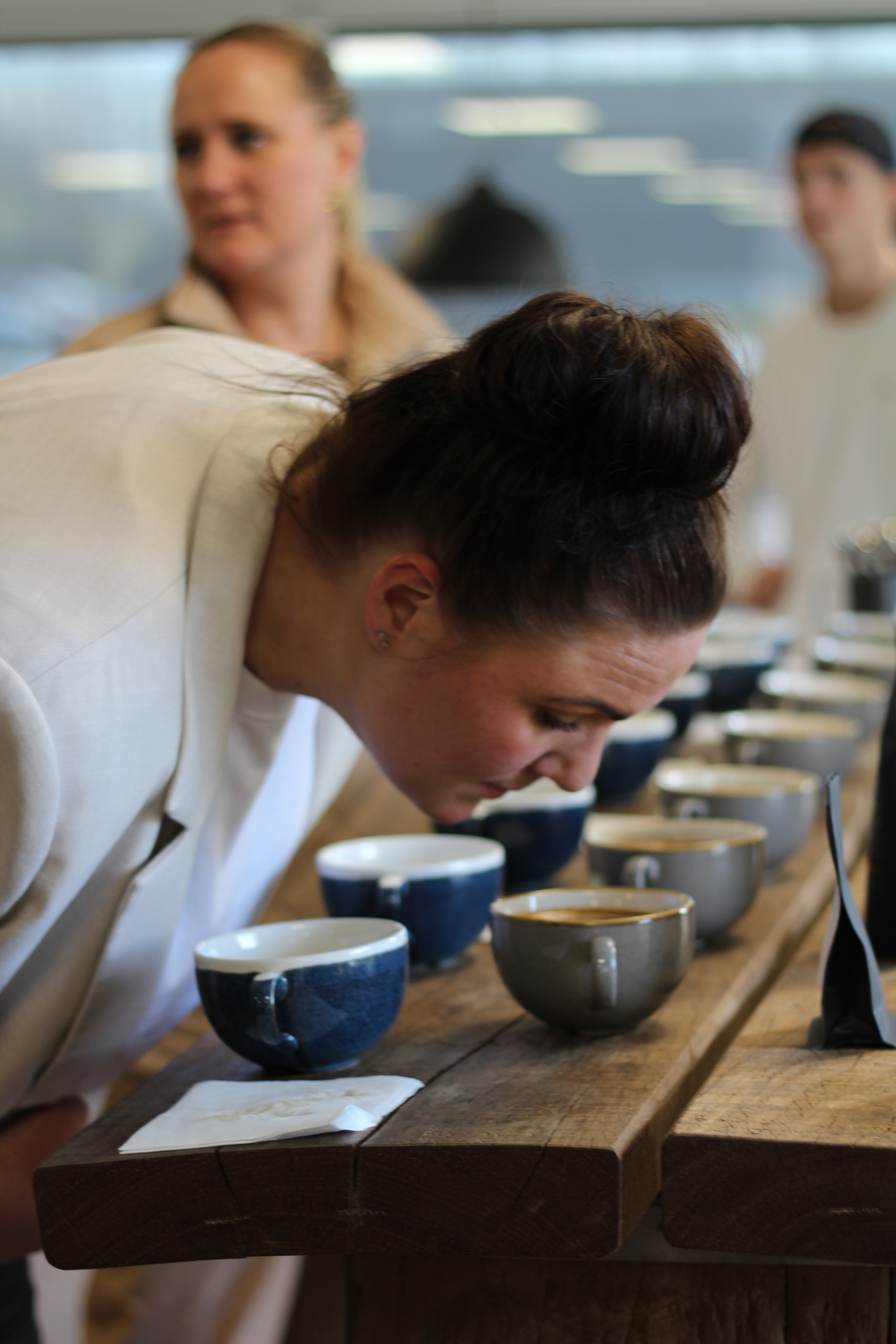 En kvinde, der tester mange kaffekopper