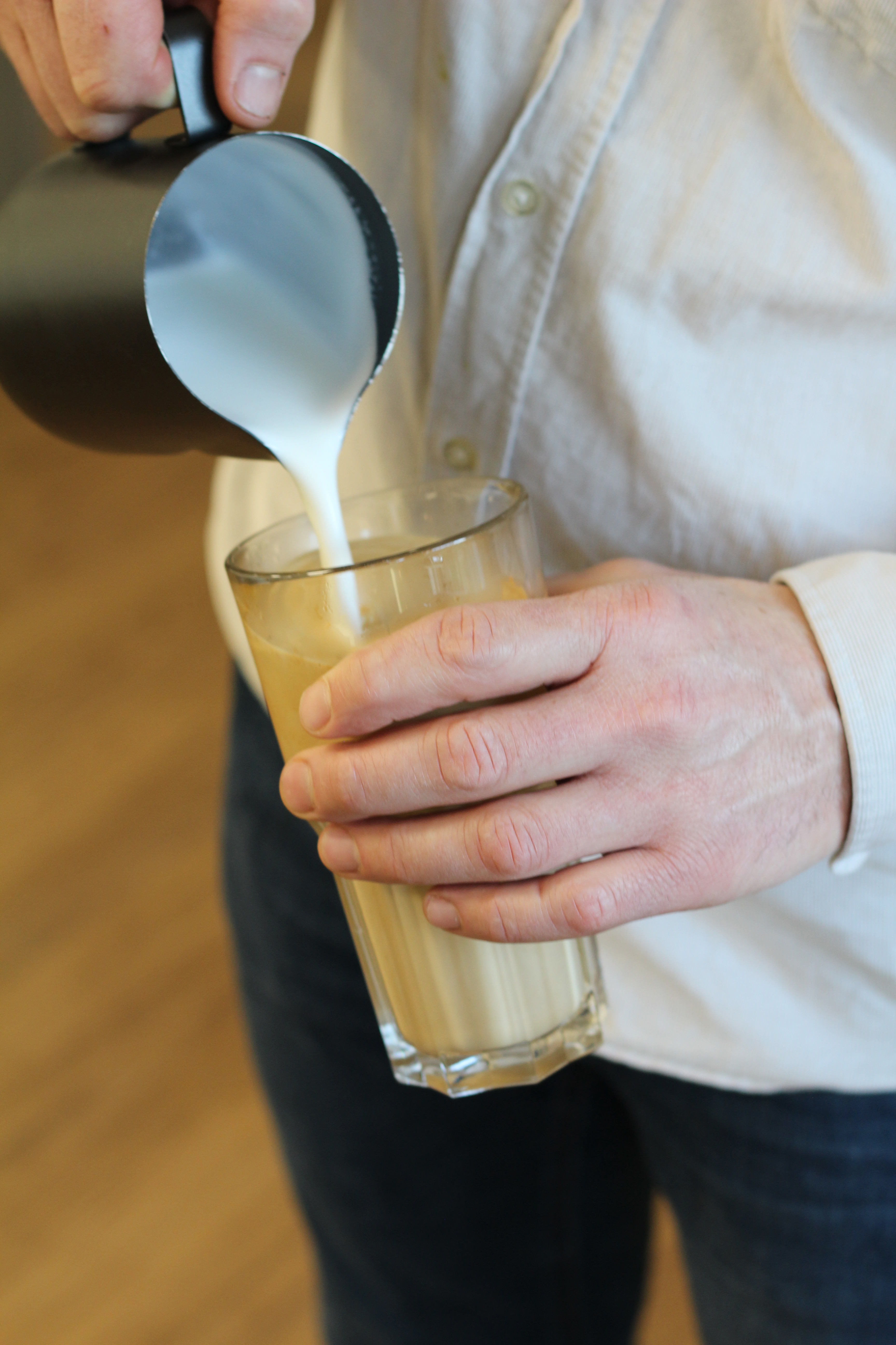 en mand laver en latte art kaffe