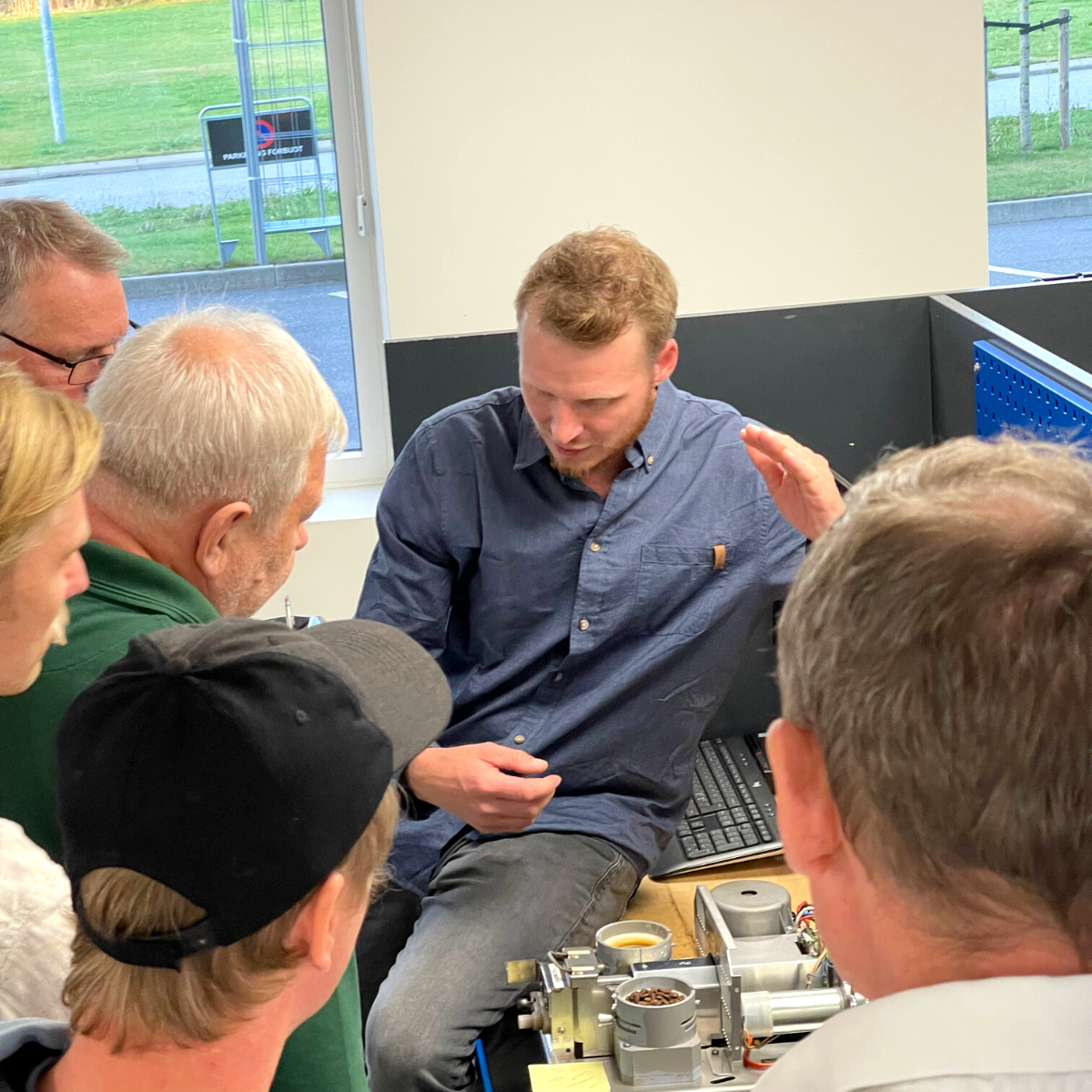 Daniel underviser en gruppe mennesker, der deltager i et kursus, som foregår i Bentax' risteri