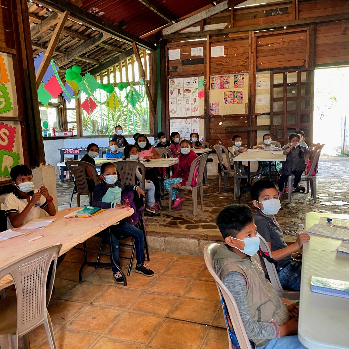 børn på skole med masks på deres ansigter 